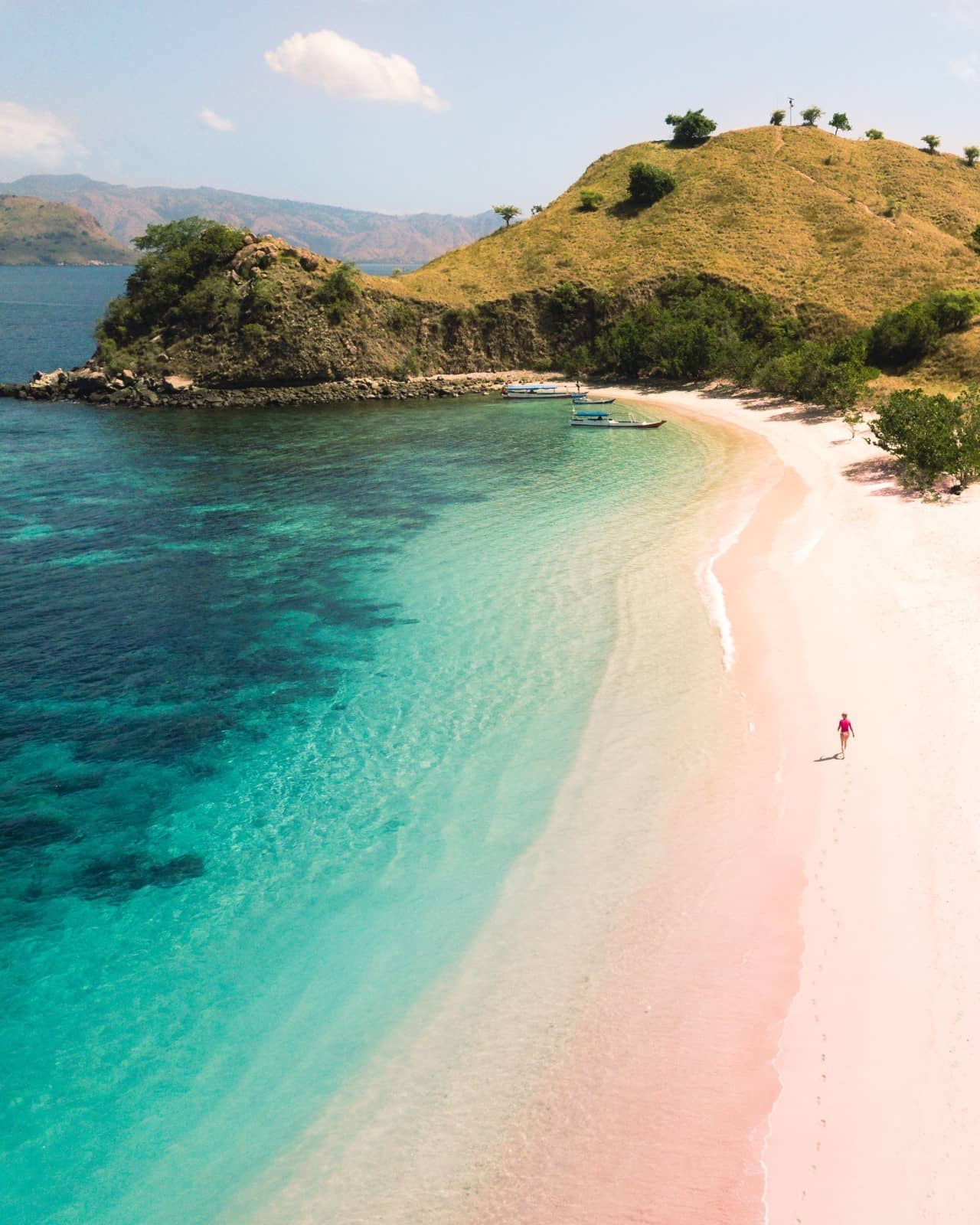 Woman walking on the exotic Pink Beach in Indonesia