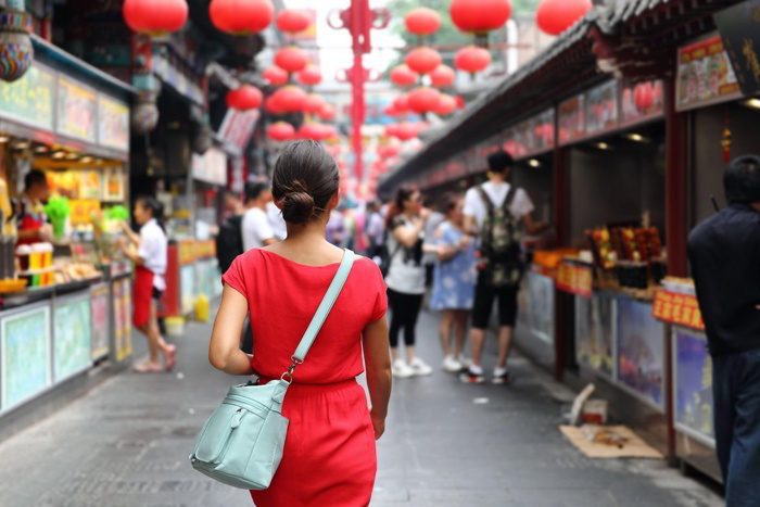 Woman walking in Wangfujing food street in China