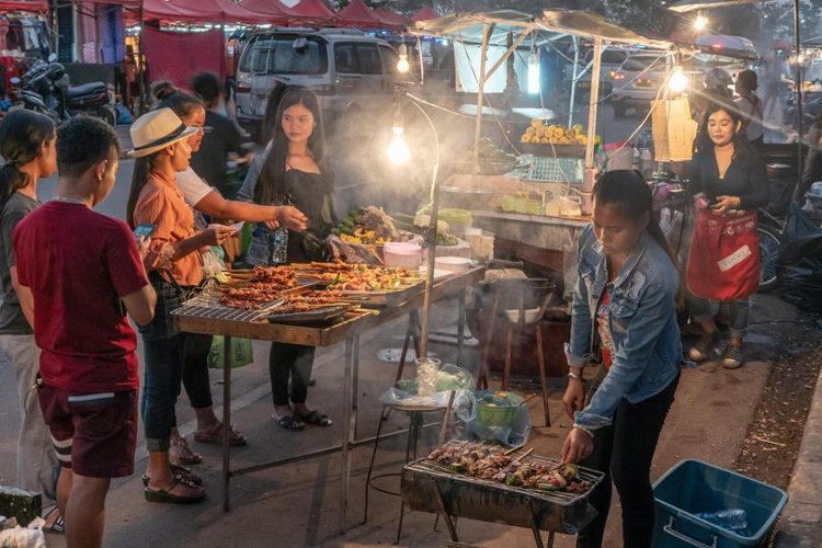 A market in Laos with people selling food