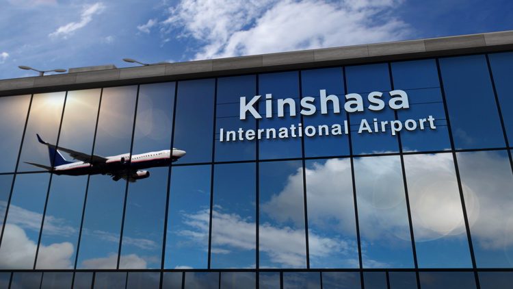 Airplane landing at Kinshasa Congo airport mirrored in terminal