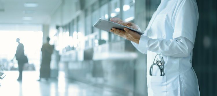 Doctor working on digital tablet on hospital background. health care in new zealand