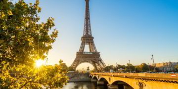 A view of Paris with the Seine River and the Eiffel tower in the background on a sunny afternoon. How To Leave The US