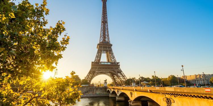 A view of Paris with the Seine River and the Eiffel tower in the background on a sunny afternoon. How To Leave The US