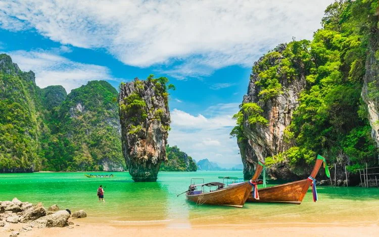 Beautiful landscape with boats for travelers in a white sand beach in Phuket, Thailand