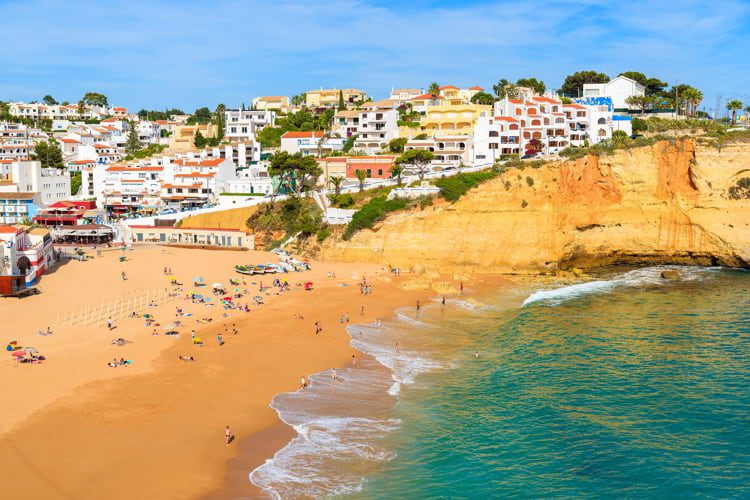View of beach with in Carvoeiro town with colorful houses on coast of Portugal