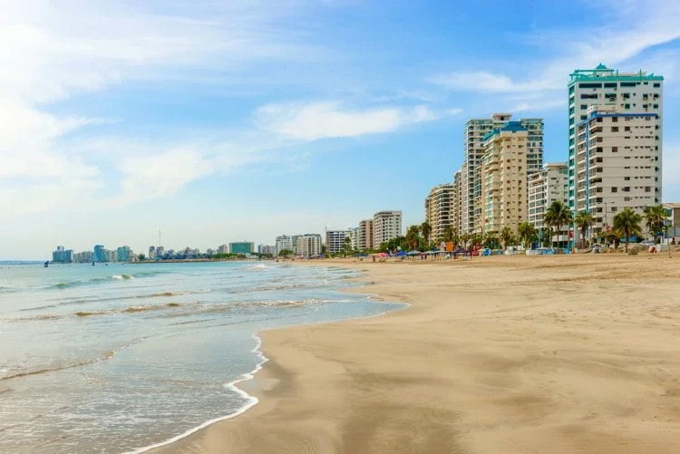 A sandy beach with beachfront apartments in in Salinas, Ecuador