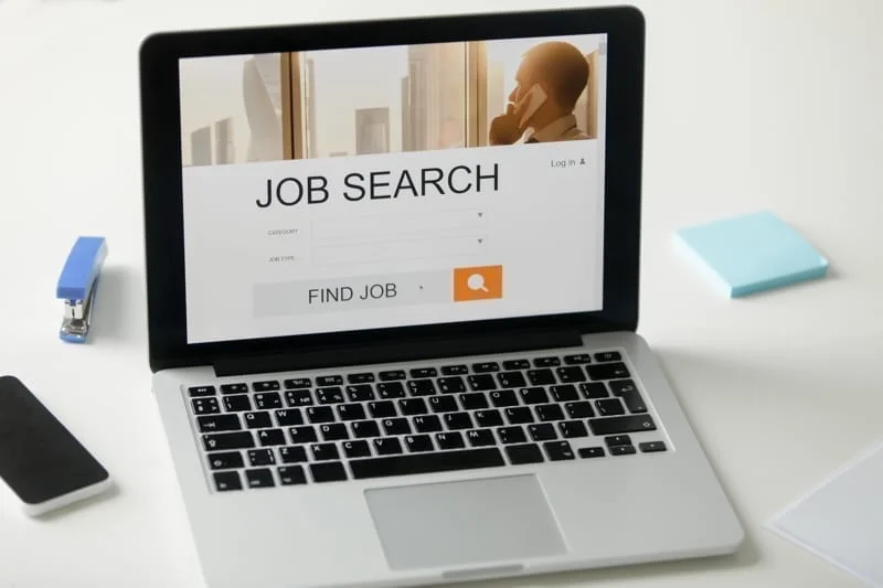 Open laptop on the desk, job search title on screen. work in colombia