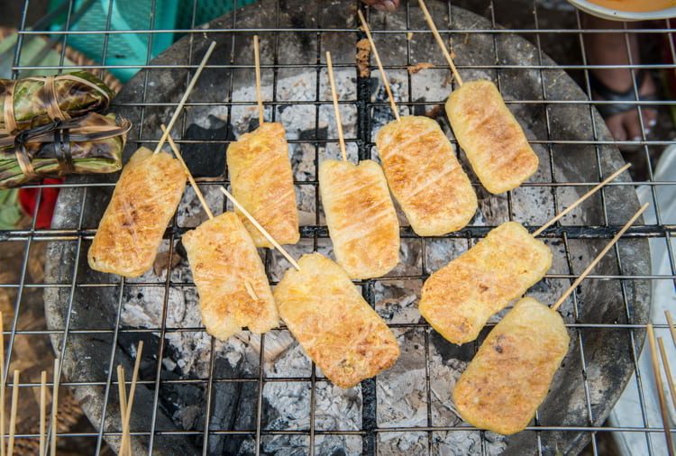 Grilled sticky rice with egg cooking and heat on coal in Luang Prabang local market, Laos.