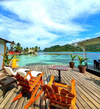 Cocotal hotel with seats in front of a clear water beach in Isla Grande, Panama