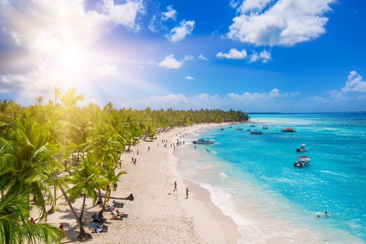 People enjoying a tropical Caribbean beach with white sands and clear waters