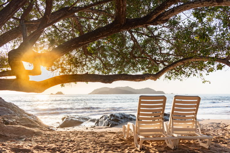 Beach chairs facing the sea at sunset in Zihuatanejo, Mexico