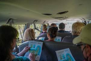 A group of people in a car with maps of Belize