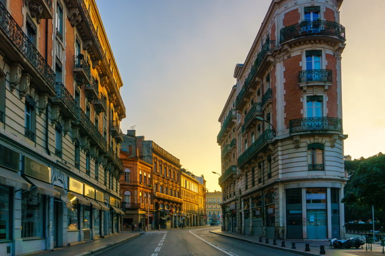 Narrow historic street with old buildings in Toulouse, France. Retirement In Europe