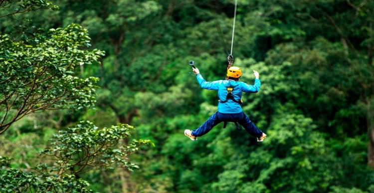 A person rappelling in the rain forest in Panama City