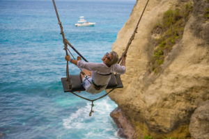 Lady on a swing over a beach in Spain