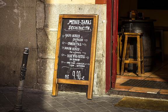 A restaurant in Spain with the lunch prices in a chalk board