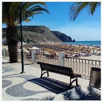 A bench in a boardwalk in a white sand beach in Portugal
