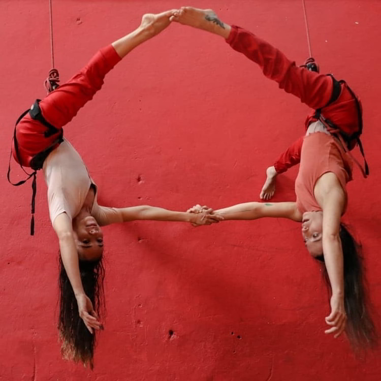 Two ladies practicing aerial suspension