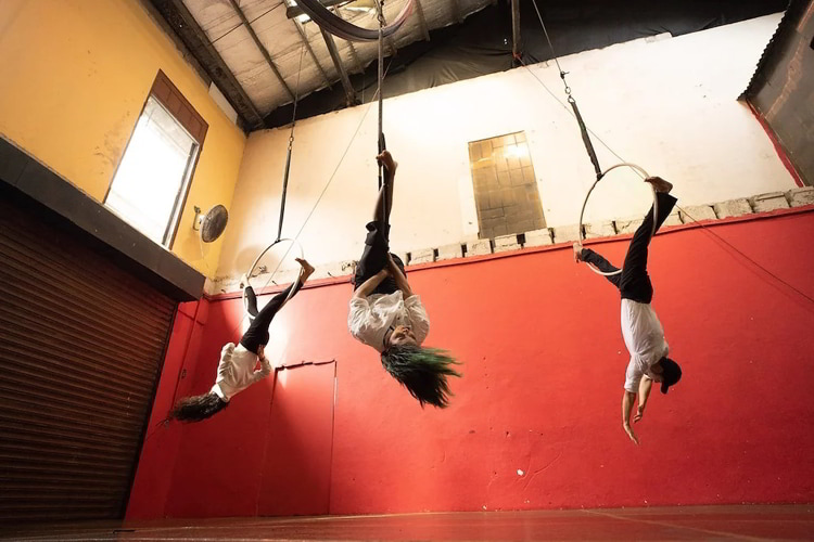 Three people practicing aerial suspension