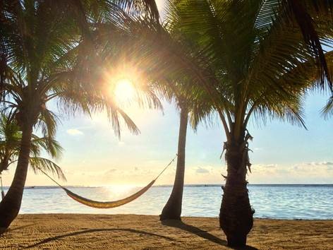 A white sand beach in Belize during sunset