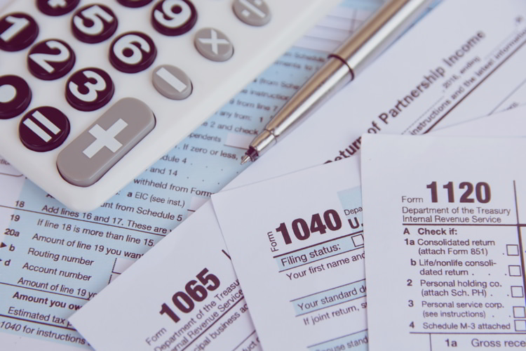 Calculator, pen on US tax form background