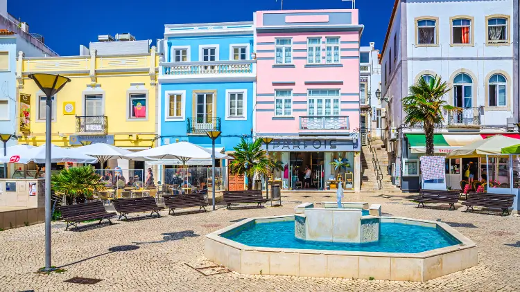 Lagos historical town centre with colorful multicolored buildings houses, fountain and benches in sunny summer day 