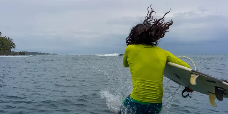 surfer gets in the water, bocas del toro, panama