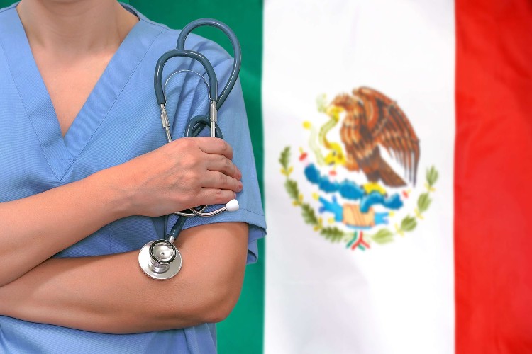 Female doctor with stethoscope in hand with the Mexican flag as background.