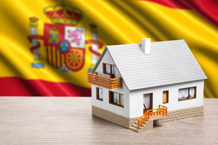 Classic house against Spanish flag background. health care in spain