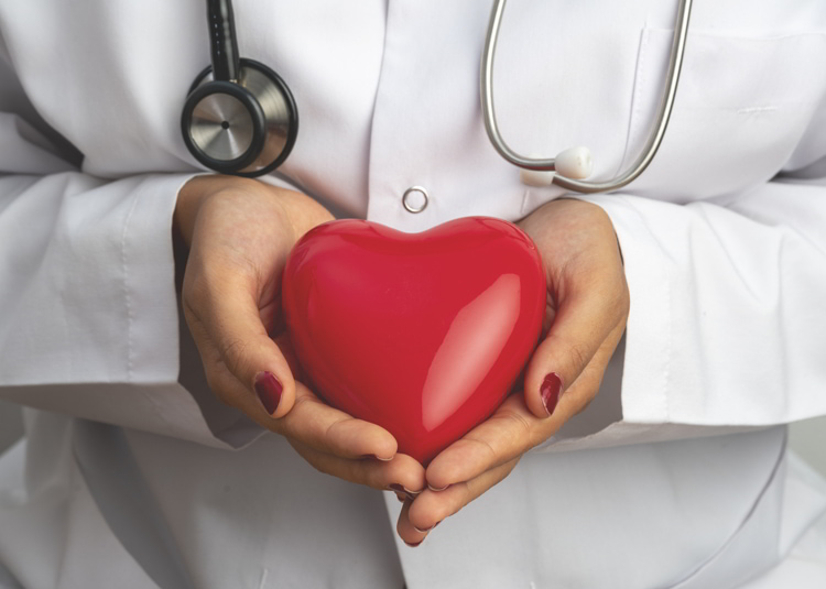 Doctor holding red heart shape in hand