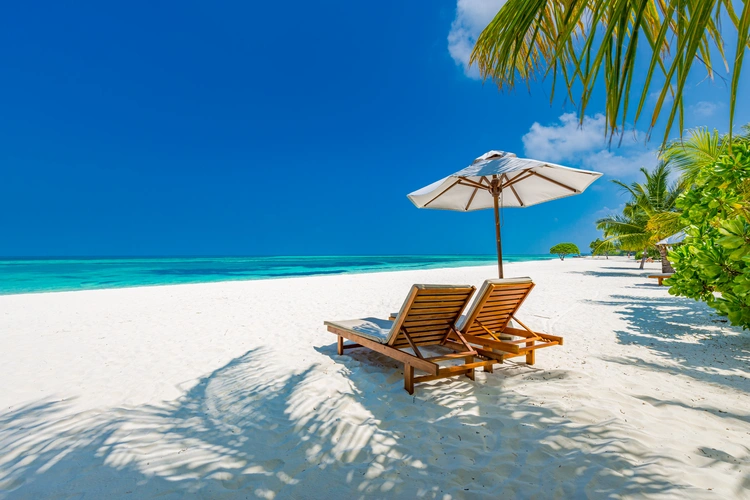Luxury beach resort, beach loungers near the sea with white sand over sea Topical island. wealth strategy