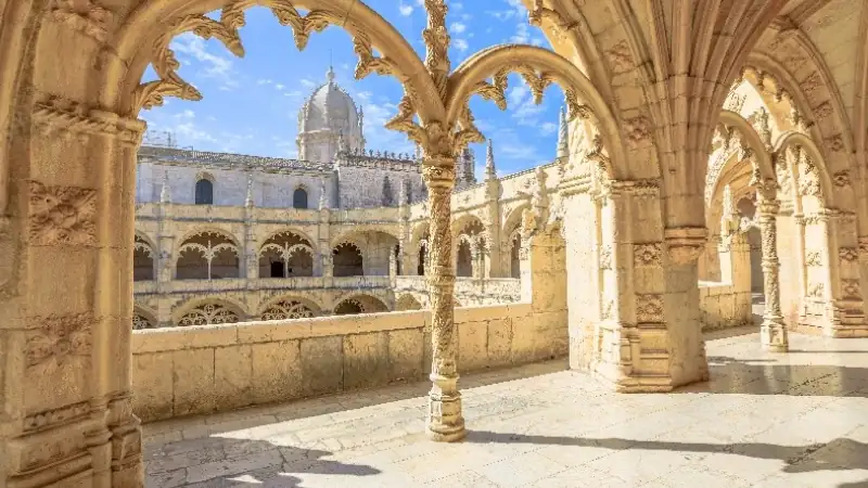 Ornate stone arches and Gothic architecture at Jerónimos Monastery in Lisbon, Portugal.