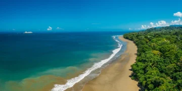 Aerial Drone View of a tropical beach in Costa Rica. Sand and water surrounded by lush rainforest