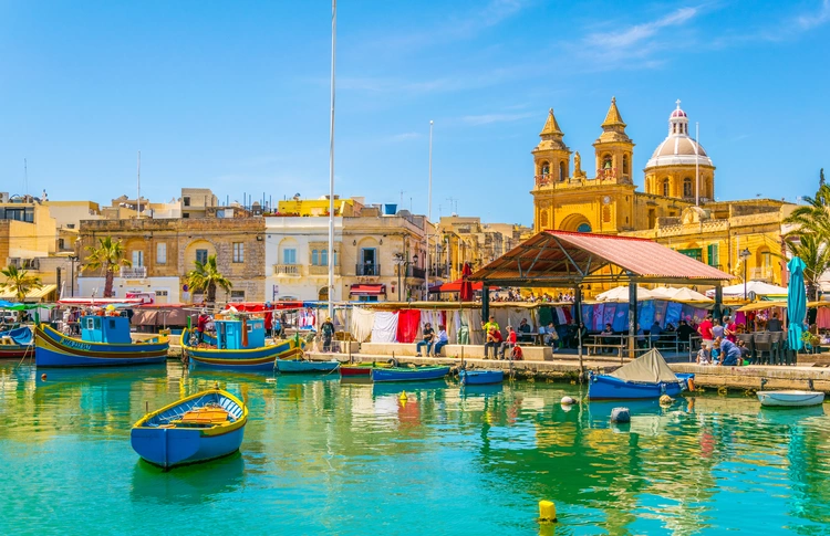 Colorful fishing boats moor in Marsaxlokk, Malta. health care in malta