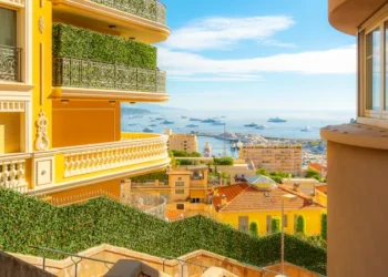 Benefits of overseas property showcased by luxury residential apartments, condos, and townhomes in the hills of Monte Carlo, Monaco, overlooking the Rock, Mediterranean Sea, and marina along the Riviera.