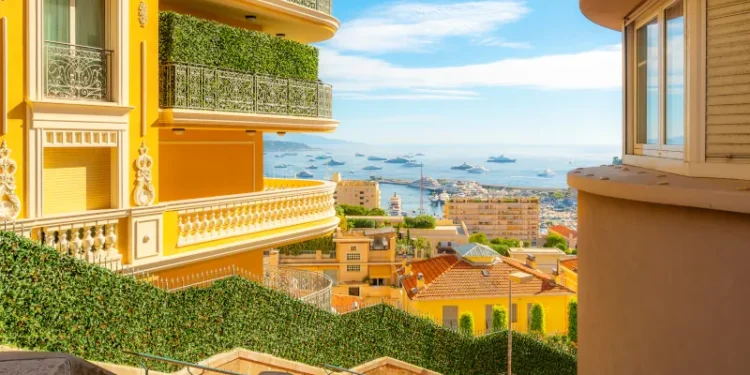 Benefits of overseas property showcased by luxury residential apartments, condos, and townhomes in the hills of Monte Carlo, Monaco, overlooking the Rock, Mediterranean Sea, and marina along the Riviera.