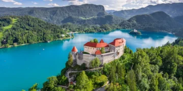 Bled, Slovenia - Aerial panoramic view of beautiful Bled Castle (Blejski Grad) with Lake Bled (Blejsko Jezero), the Church of the Assumption of Maria and Julian Alps at background on a summer day