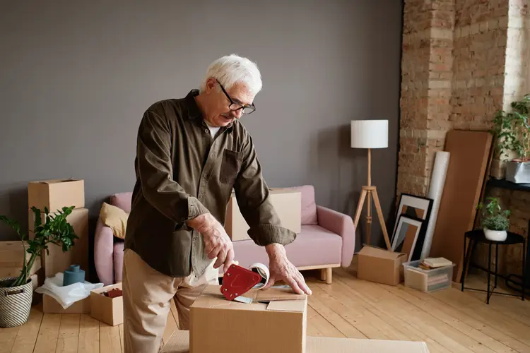 Senior man preparing boxes so he can move. move to thailand