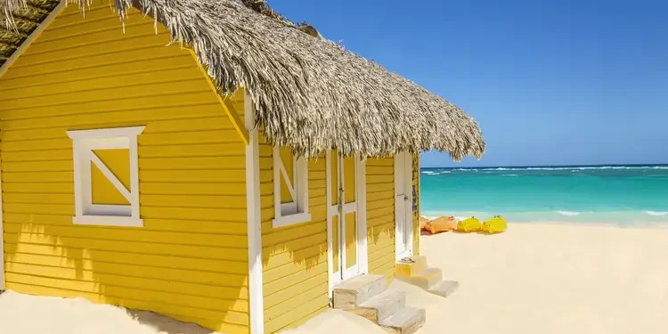 Wooden yellow hut on the beach covered with thatch and kayaks. most valuable commodity