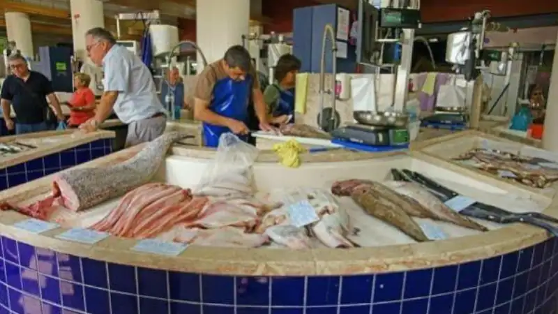 Fishmongers preparing and selling fresh fish
