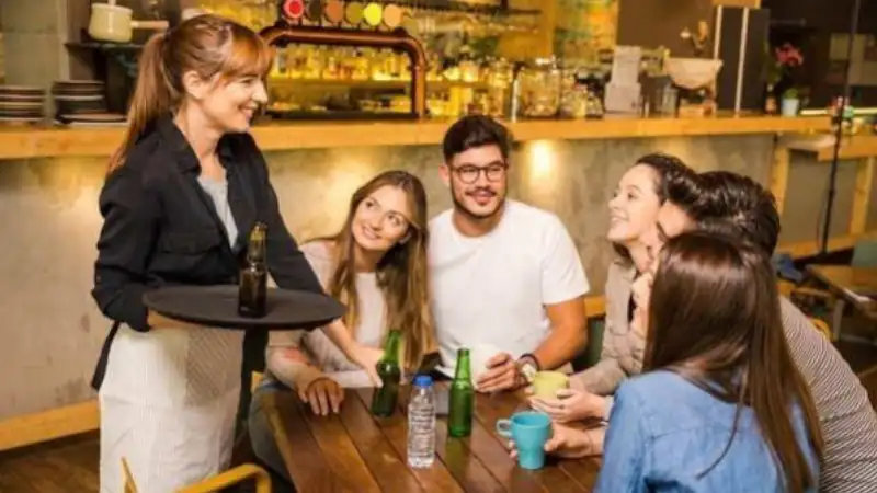 Smiling waitress serving drinks