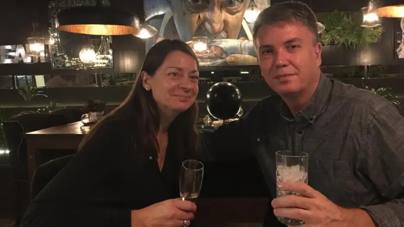 man and a woman sitting together at a restaurant or bar, each holding a drink.