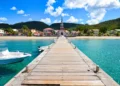 Wooden pier leading to a colorful coastal village with a church
