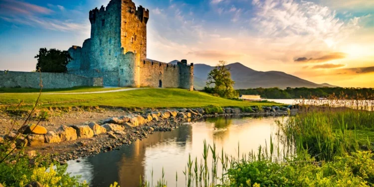 Ancient old Fortress Ross Castle ruin with lake and grass in Ireland during golden hour nobody