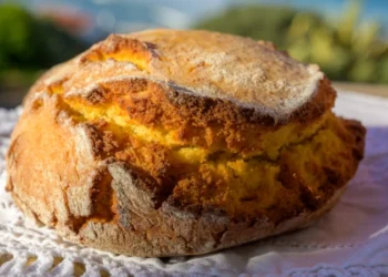 Enjoy Broa Portugeese homemade oven baked yellow corn bread served outdoor with view on blue Atlantic ocean in Lisbon area, Portugal