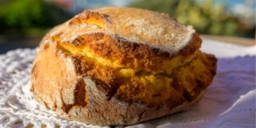 Enjoy Broa Portugeese homemade oven baked yellow corn bread served outdoor with view on blue Atlantic ocean in Lisbon area, Portugal