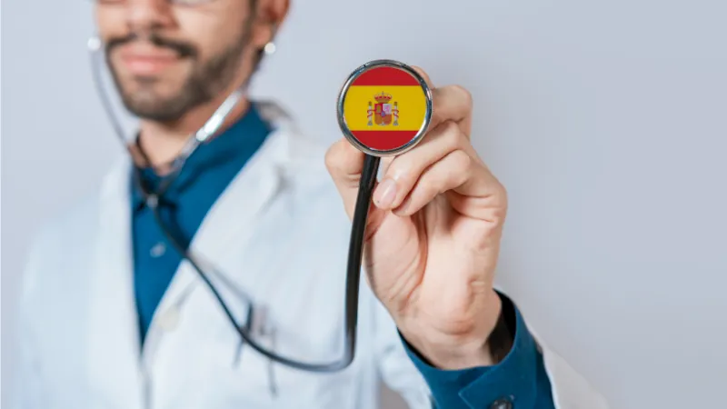 Doctor holding stethoscope with Spain flag. Spanish Health and Care Concept, Spain flag on stethoscope