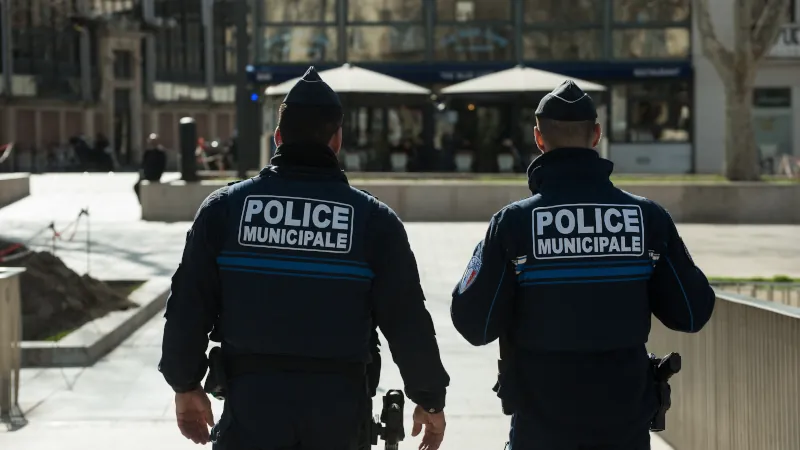 Narbonne - France Portrait on back view of two policemen patrolling in the street