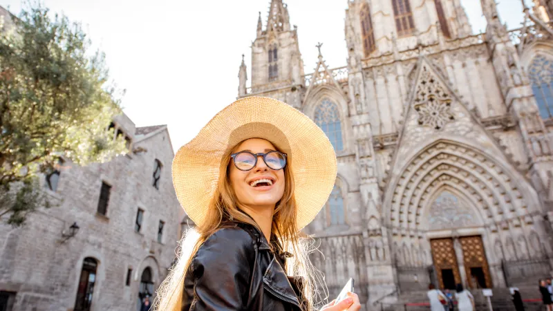 Young woman tourist standing in front of the famous saint Eulalia church during the morning light in Barcelona city