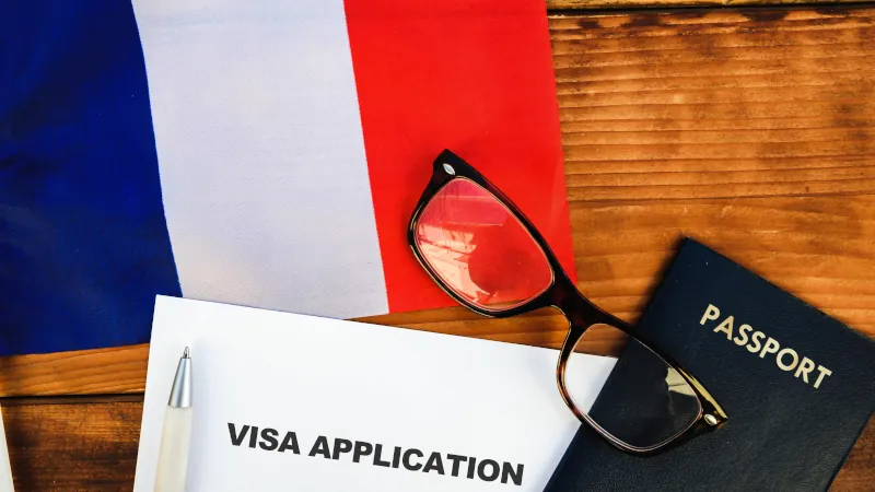 Flag of France , visa application form and passport on table